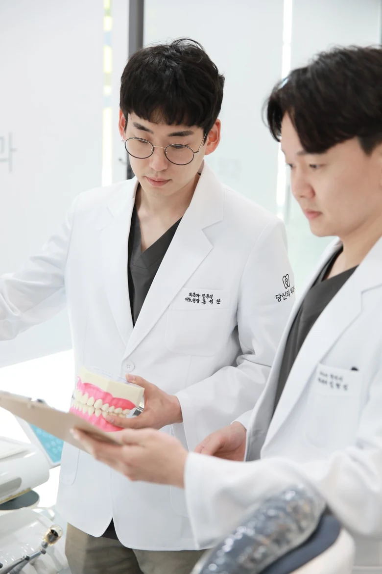 두 대표원장이 치아 모형을 함께 보며 치료 방향을 상의하는 모습