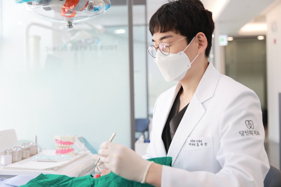 치과 의사가 마스크를 착용하고 진료 도구를 준비하는 모습