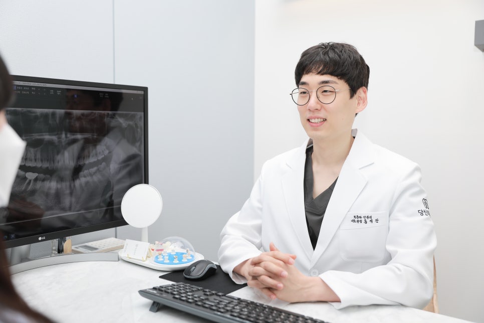 치과 의사가 환자와 상담하며 미소 짓는 모습