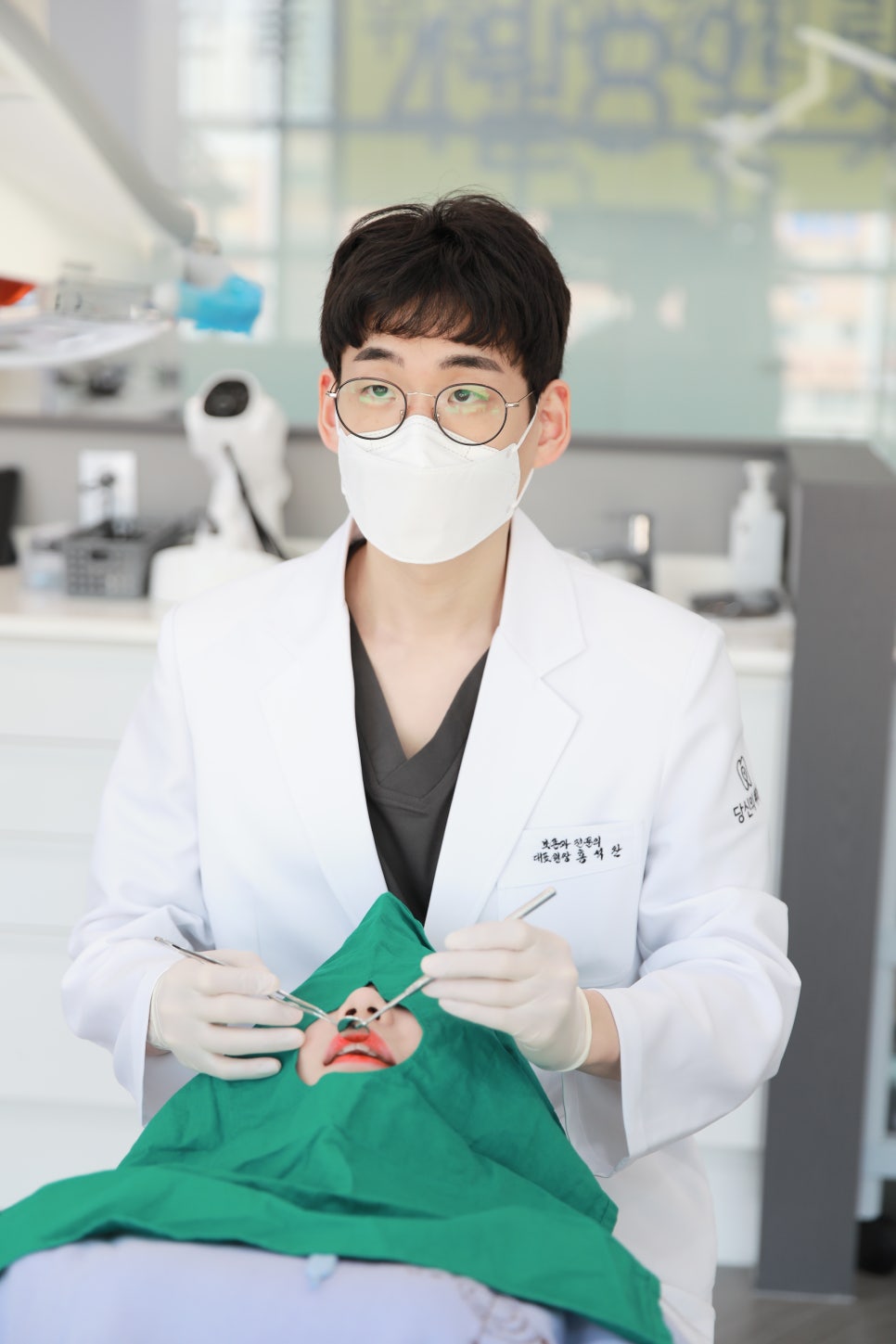 마스크를 착용한 치과 의사가 환자를 진료하는 모습
